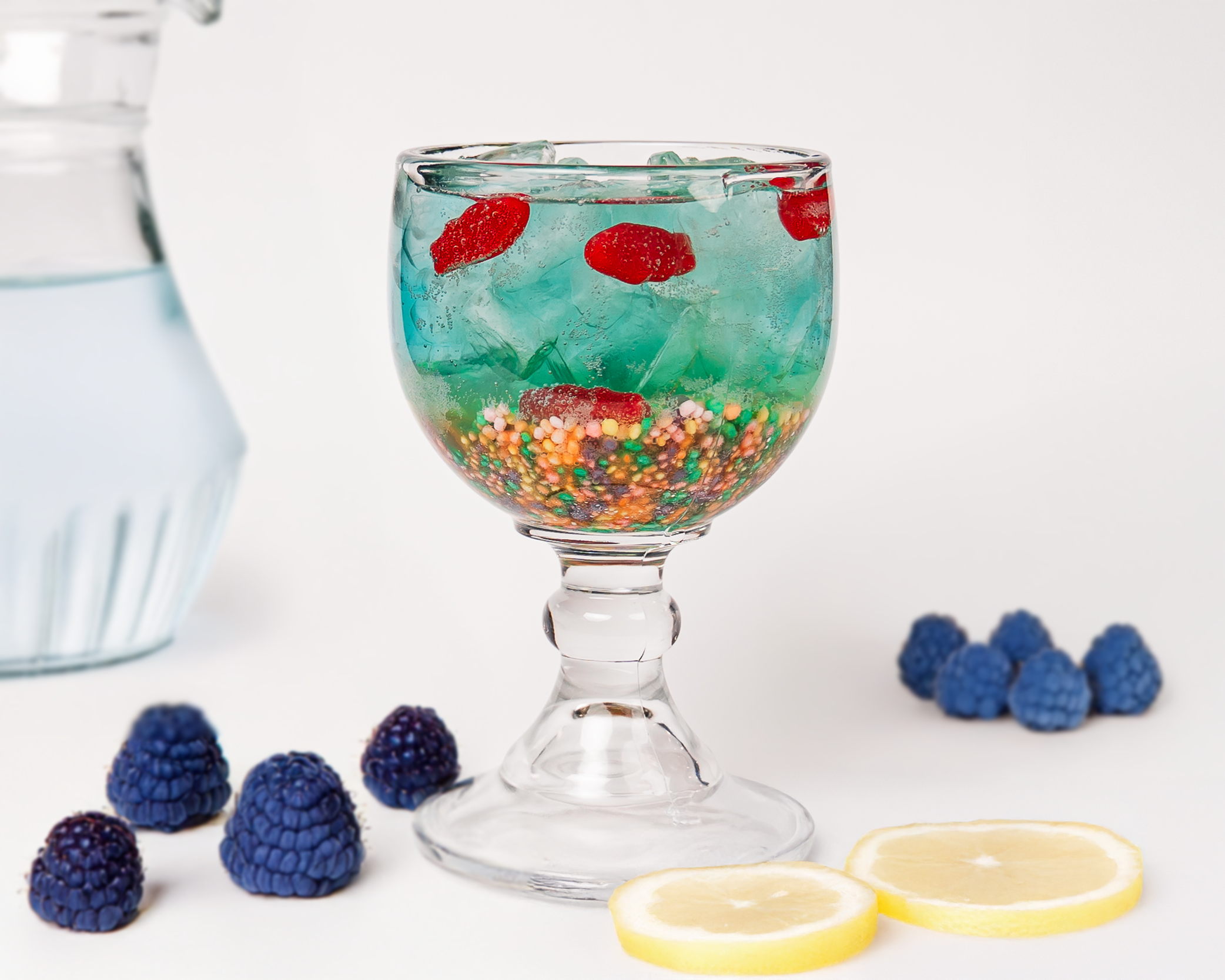 Vibrant blue refresher drink in a wide glass with ice and soda bubbles.