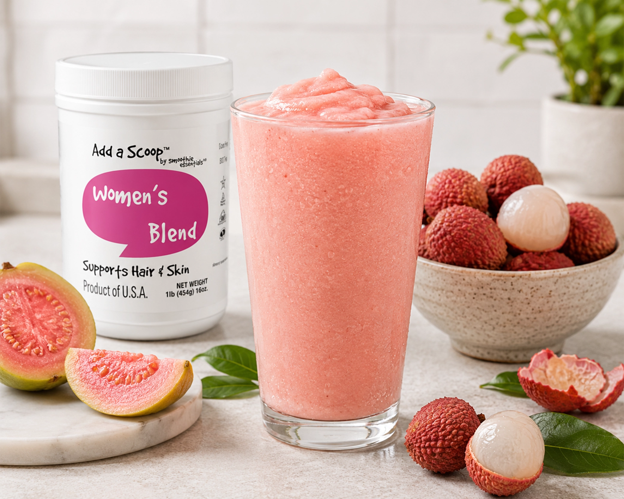 Guava lychee smoothie staged on a neutral kitchen countertop with fresh guava, lychee fruit, and Women's Blend supplement packaging from Add A Scoop Smoothie Essentials.