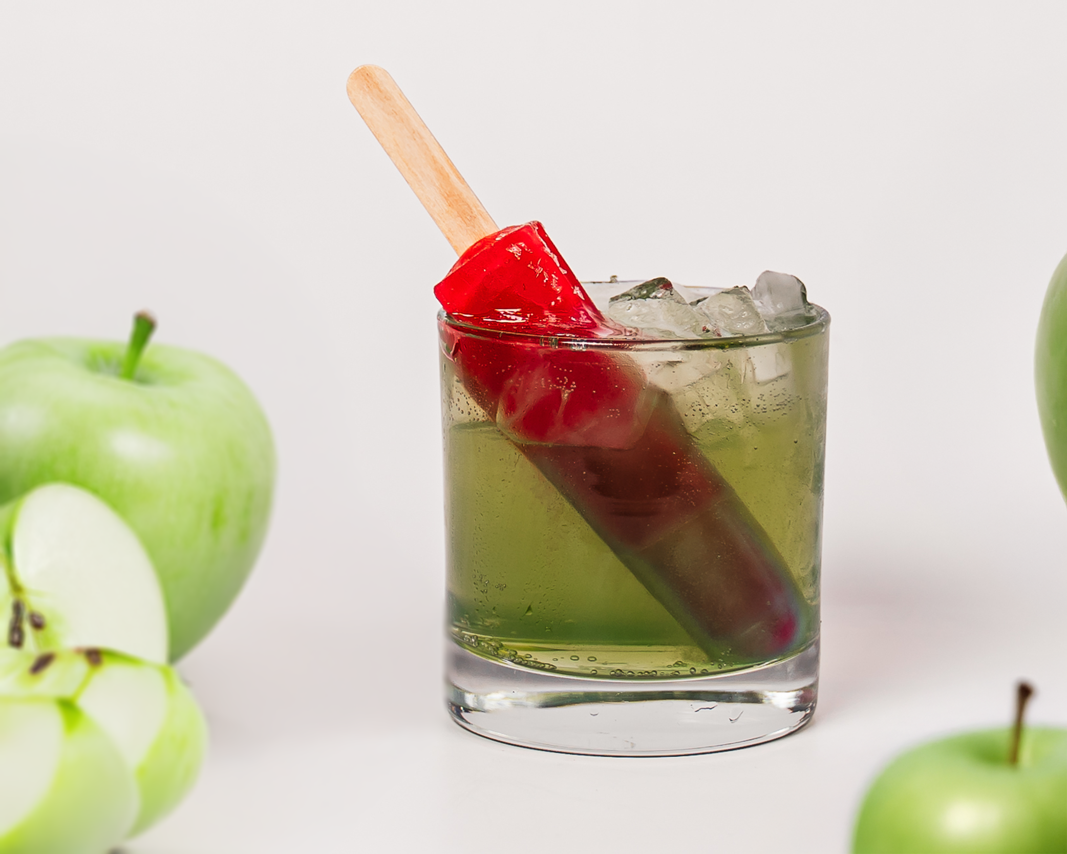 Bright fruity mocktail in a glass with popsicle-themed garnishes.
